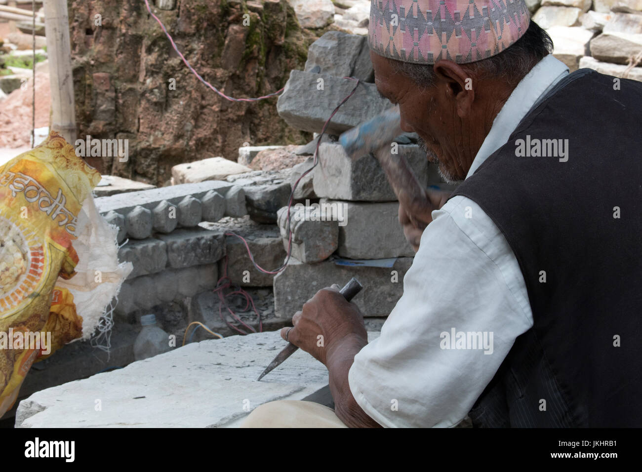 Eine ältere Steinmetz, der aus dem Ruhestand zu arbeiten auf den Wiederaufbau nach dem Erdbeben Bhaktapur-Kathmandu Nepal gekommen ist Stockfoto