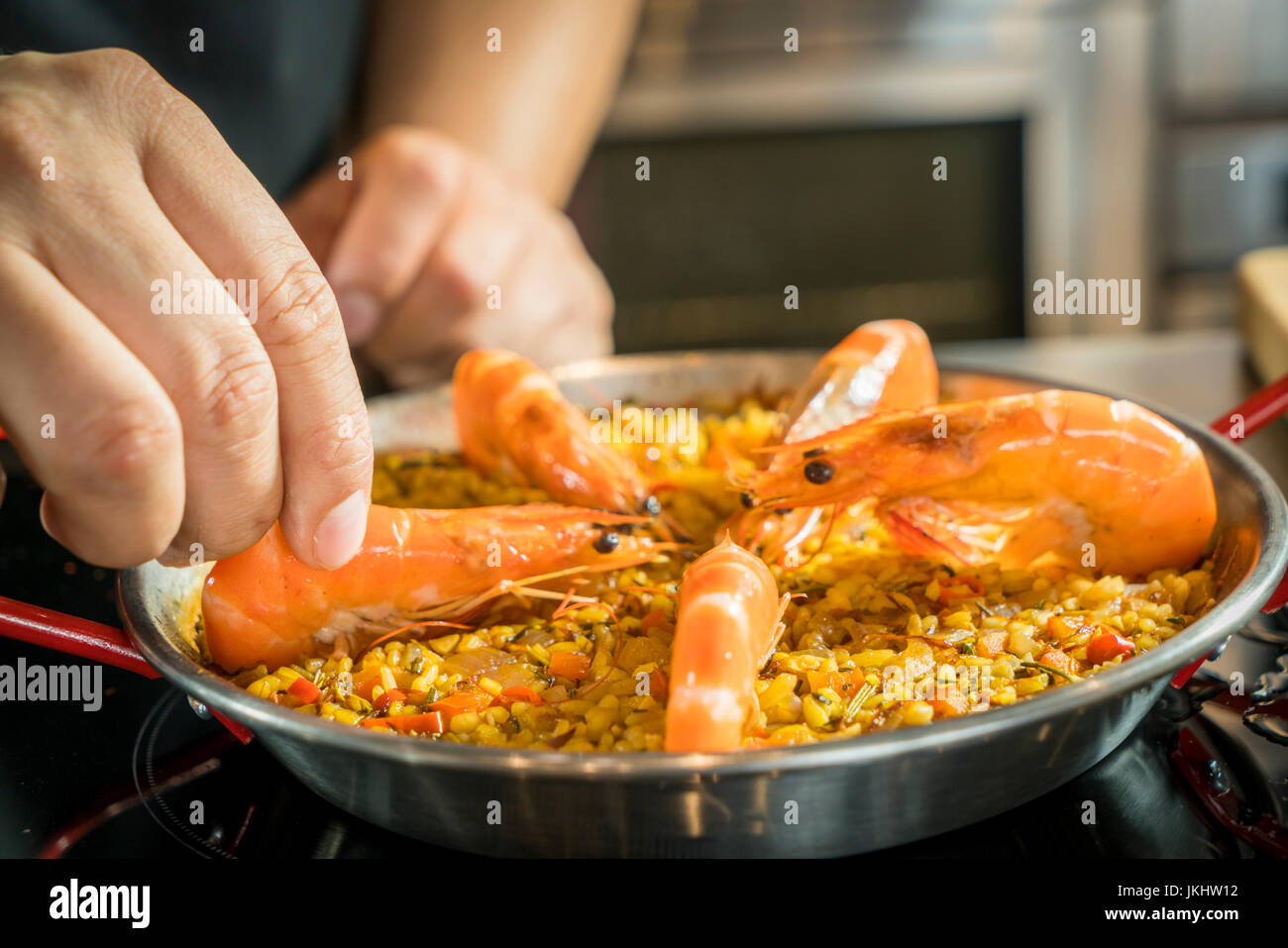 Küchenchef ist Paella Meeresfrüchte hinzufügen, Nahaufnahme Stockfoto