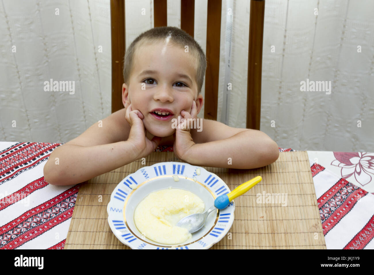 Kind Junge sitzt am Esstisch Stockfoto