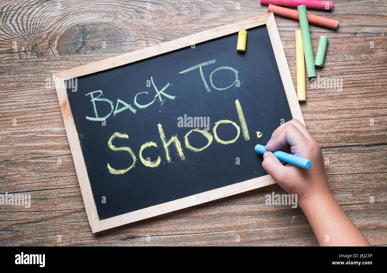 kleine Hand schreiben zurück zur Schule auf einer Kreidetafel Stockfoto