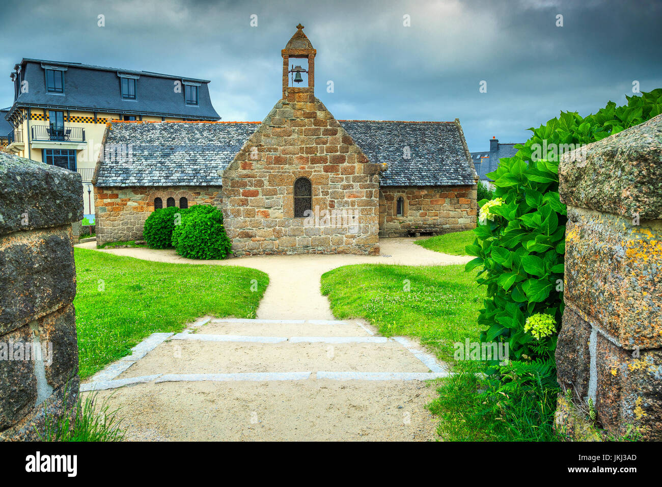 Typische steinerne Kapelle im Garten mit Hydrangea blüht, Perros-Guirec, Bretagne, Frankreich Stockfoto