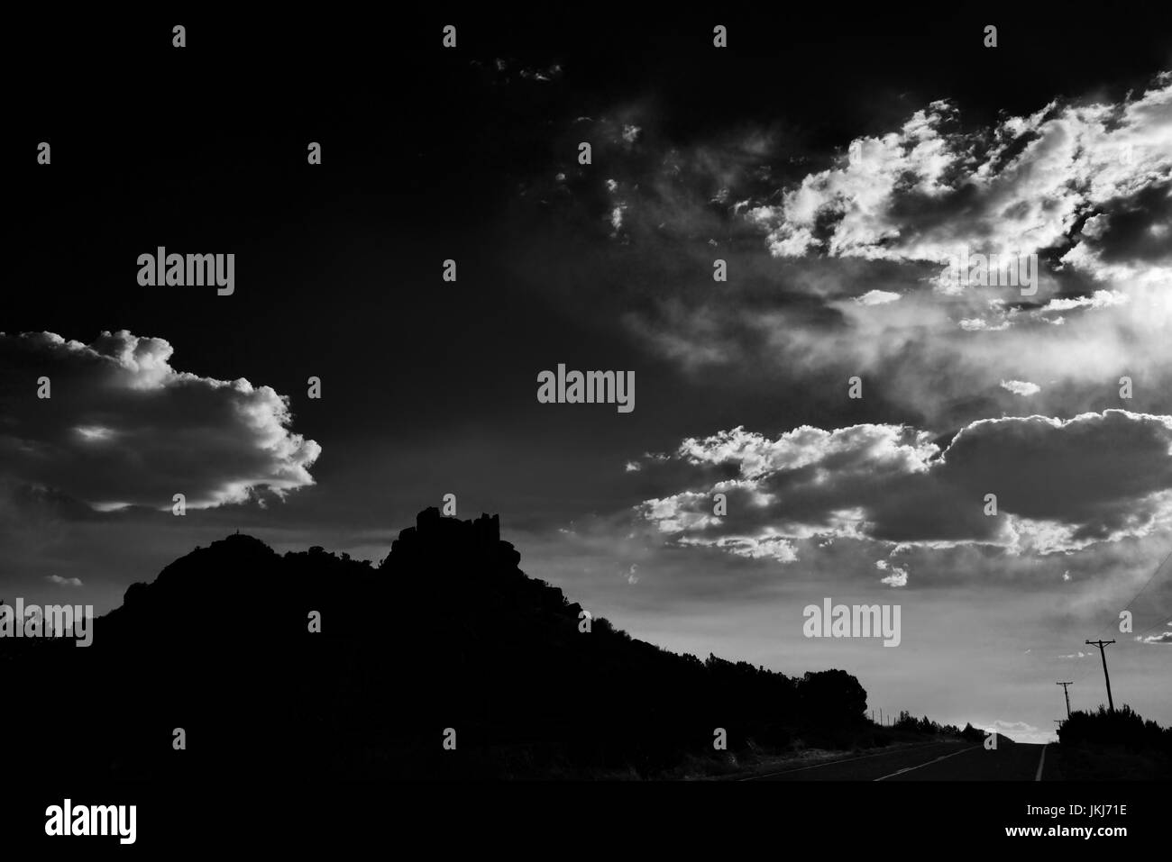 Eine schwarze und weiße Südwesten Szene in Santa Fe, New Mexico mit Moody Wolken, Felsformationen, und Telefonmasten. Stockfoto
