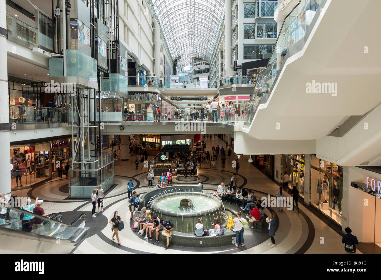 Käufer machen Sie eine Pause an einem grossen Brunnen in der Toronto Eaton Centre Einkaufszentrum und touristischen Anschlag in der Innenstadt von Toronto Ontario Kanada sitzen Stockfoto