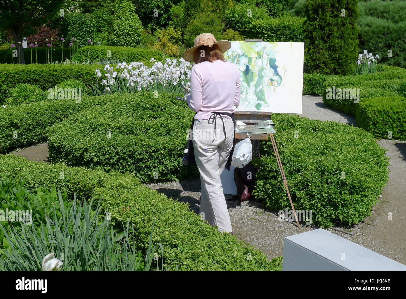 Toronto, Ontario Kanada: Frau Malerei Blumen im Sommer im Freien in einem formellen öffentlichen Garten. Stockfoto