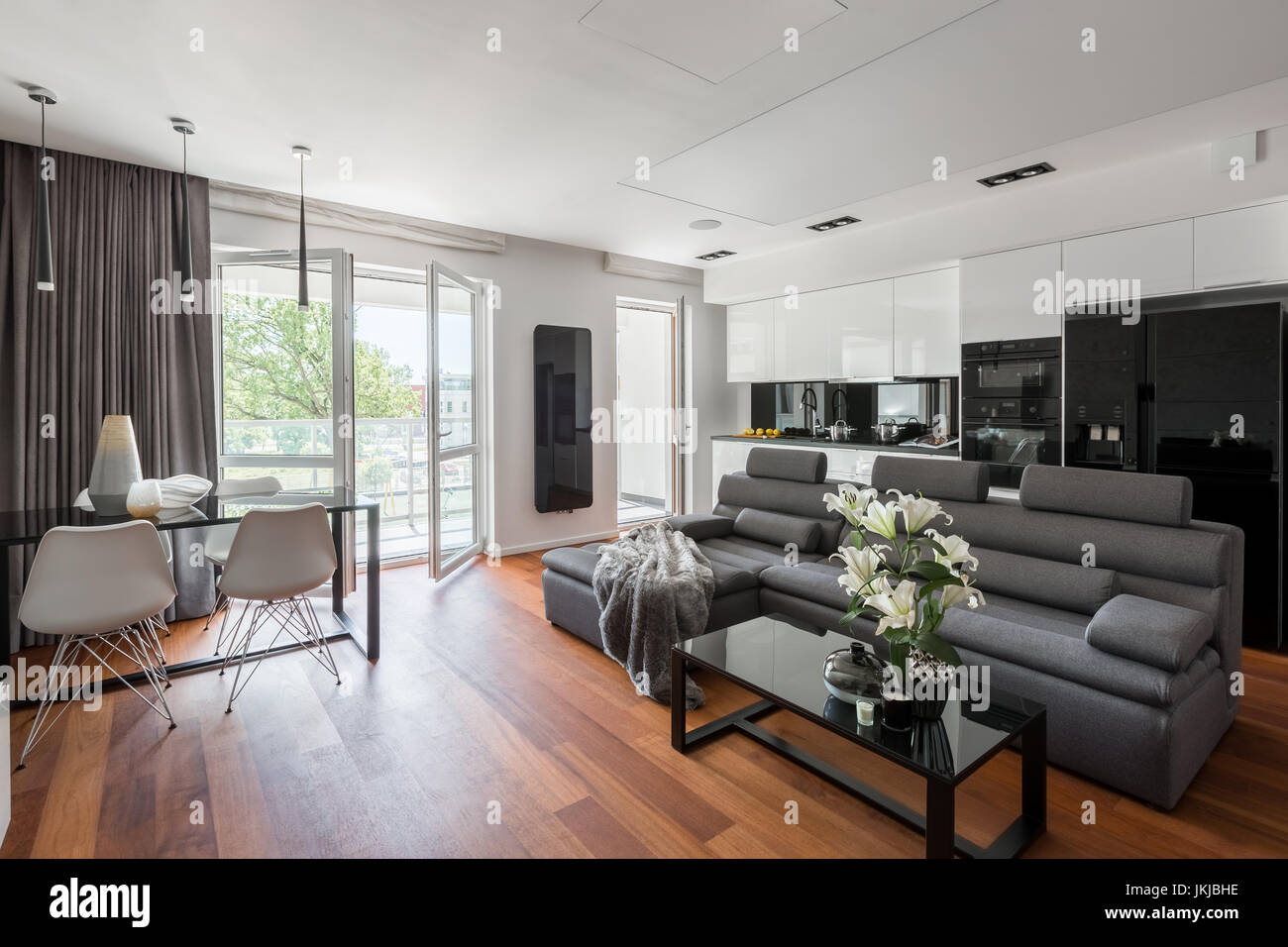 Zeitgenössische Wohnzimmer mit grauen Sofa, Tisch und Balkon Stockfoto