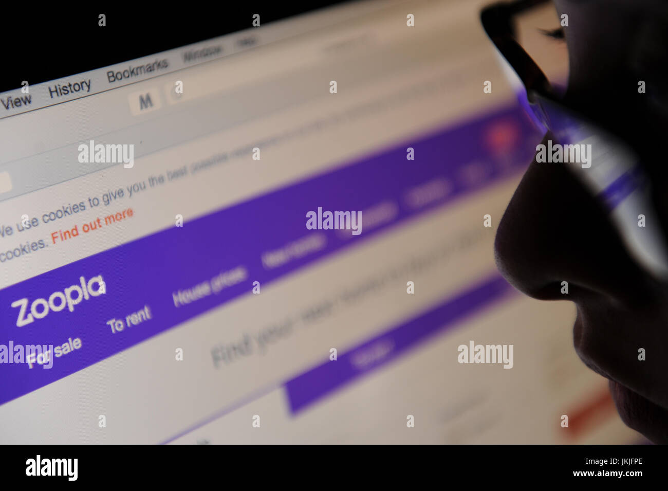 Eine Frau schaut sich die zoopla Website auf einem Bildschirm Stockfoto Eine Frau schaut sich die zoopla Website auf einem Bildschirm Stockfoto