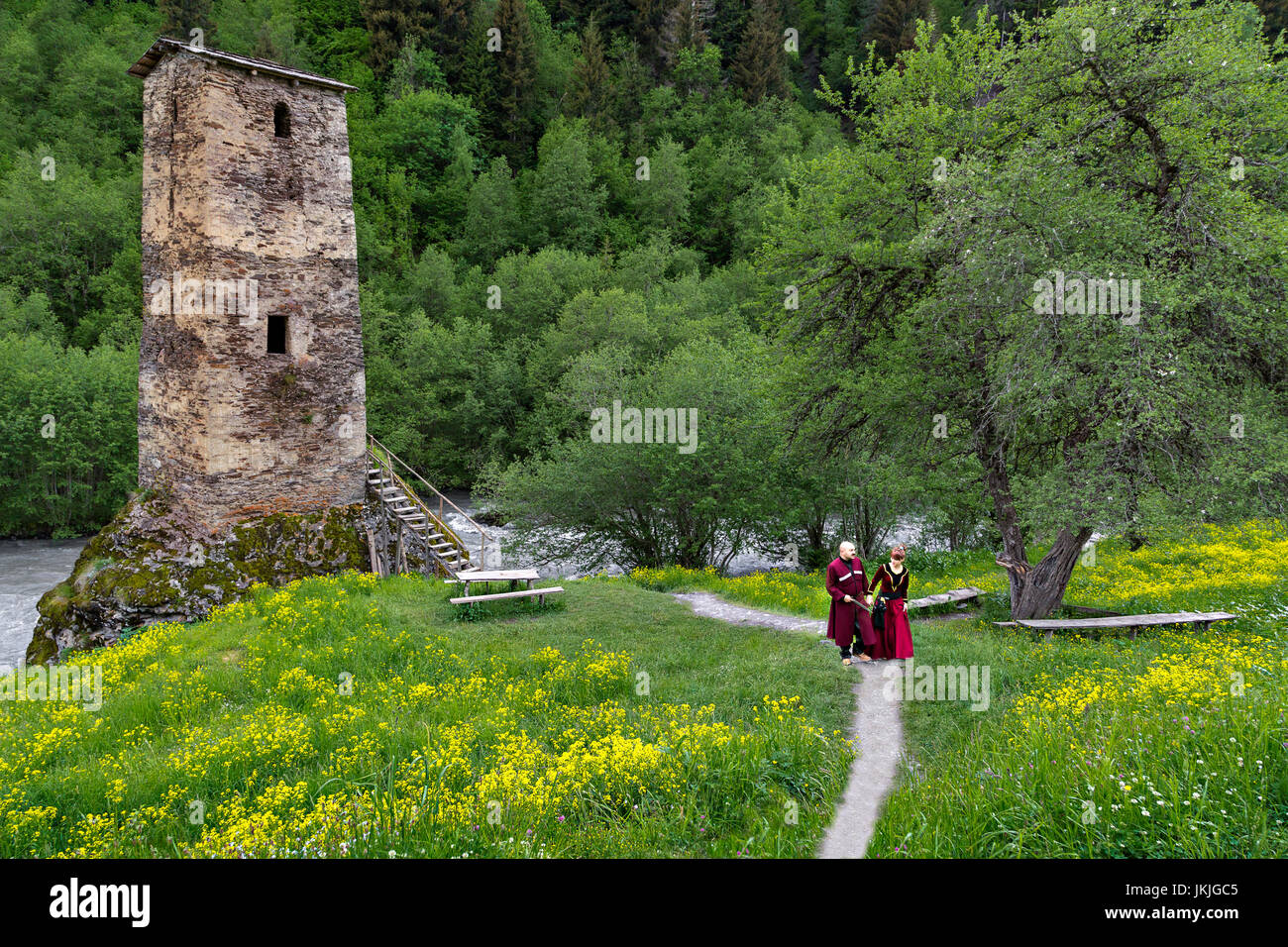 Georgische Mann und Frau in Trachten in der Nähe von einem mittelalterlichen Turm, Georgia. Stockfoto