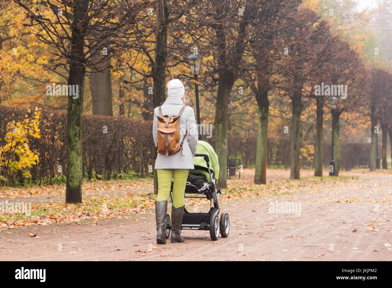 Frau mit Kinderwagen im Herbst Park zu Fuß Stockfoto