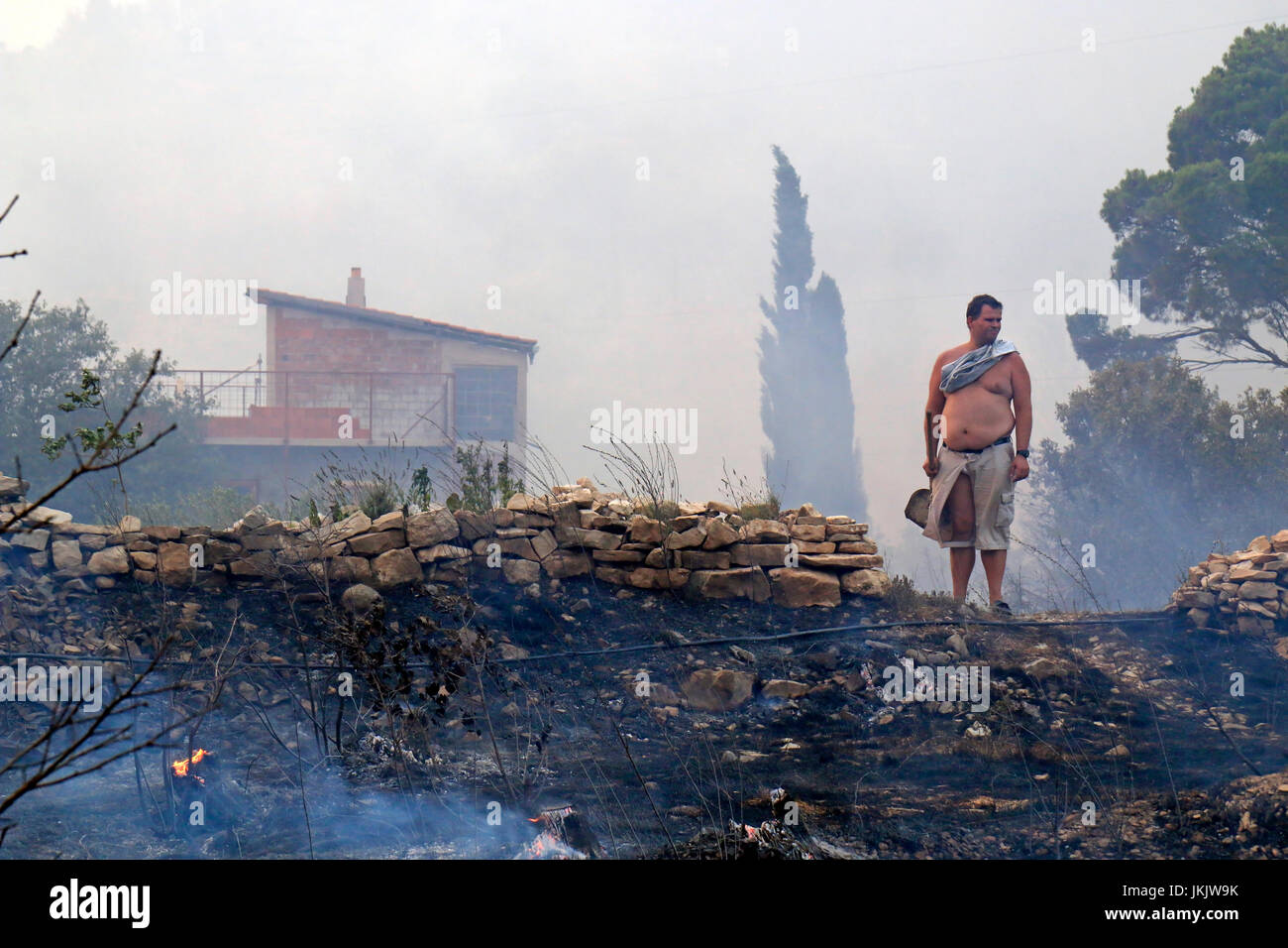 Zrnovnica, Split, Kroatien - 17. Juli 2017: Mann stand auf den Trümmern nach der Verteidigung von der massiven Wildfire Abbrennen der Wälder und Dörfer aro Stockfoto