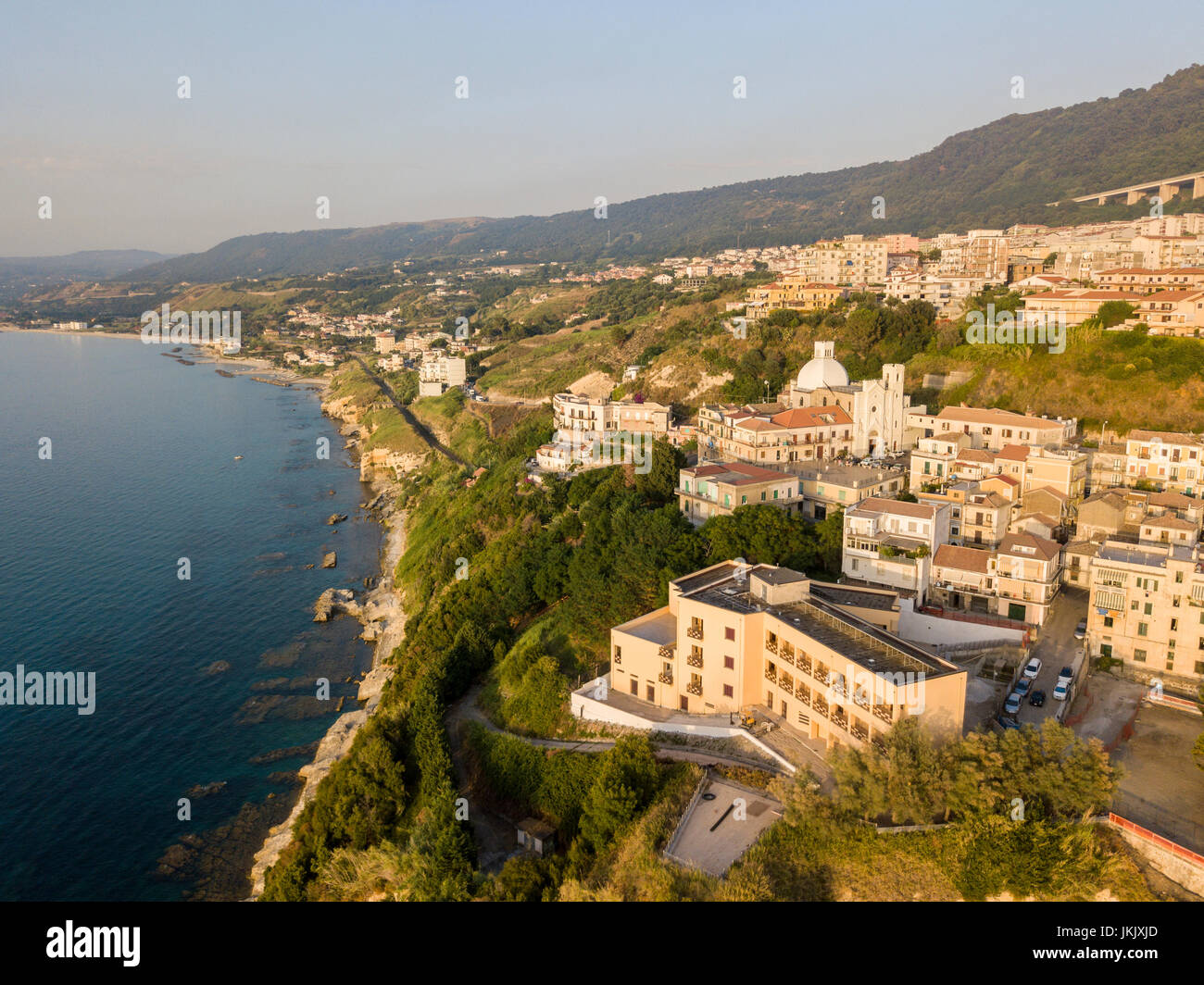 Luftaufnahme des Pizzo Calabro bei Sonnenuntergang, Kalabrien, Italien. Häuser auf dem Felsen aus dem Meer gesehen Stockfoto