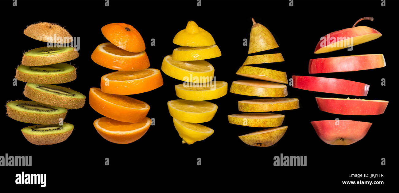 Kreatives Konzept mit Lebensmitteln. Satz von geschnittenem Obst auf schwarzem Hintergrund isoliert. Fliegen, Zitrone, Orange, Kiwi, Birne, Apfel. Leichtsinn Obst schwebend, in der ein Stockfoto