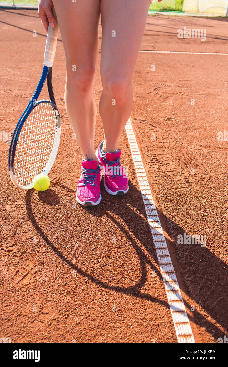 Weibliche Beine mit Tennisschläger Stockfoto