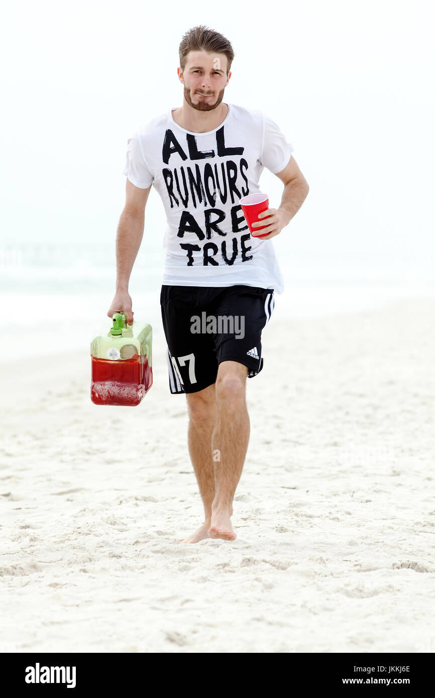 Panama City Beach, Florida. Spring Break, 2011. Junge Mann trägt Getränke am Strand. Stockfoto