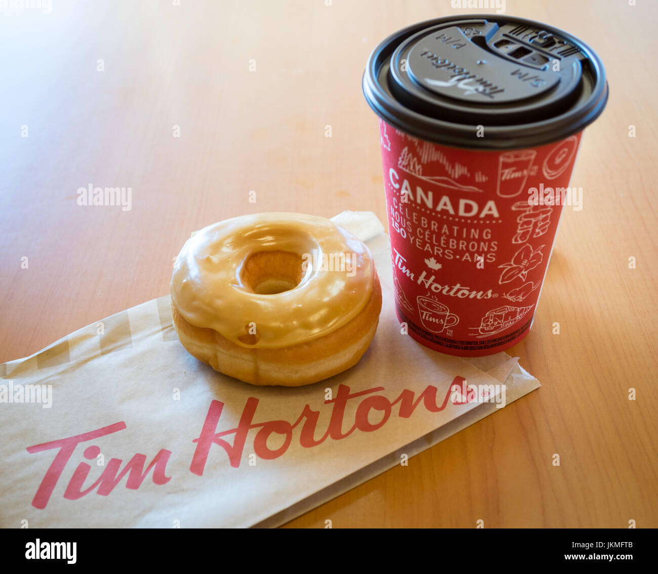 Ein Tim Hortons Ahorn Dip Krapfen und Kaffee. Stockfoto