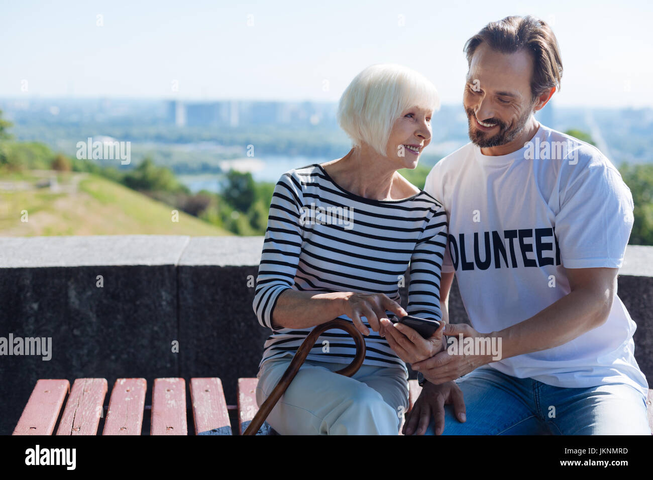 Positiv inspirierende Frau zeigt Bilder von ihren Enkeln Stockfoto