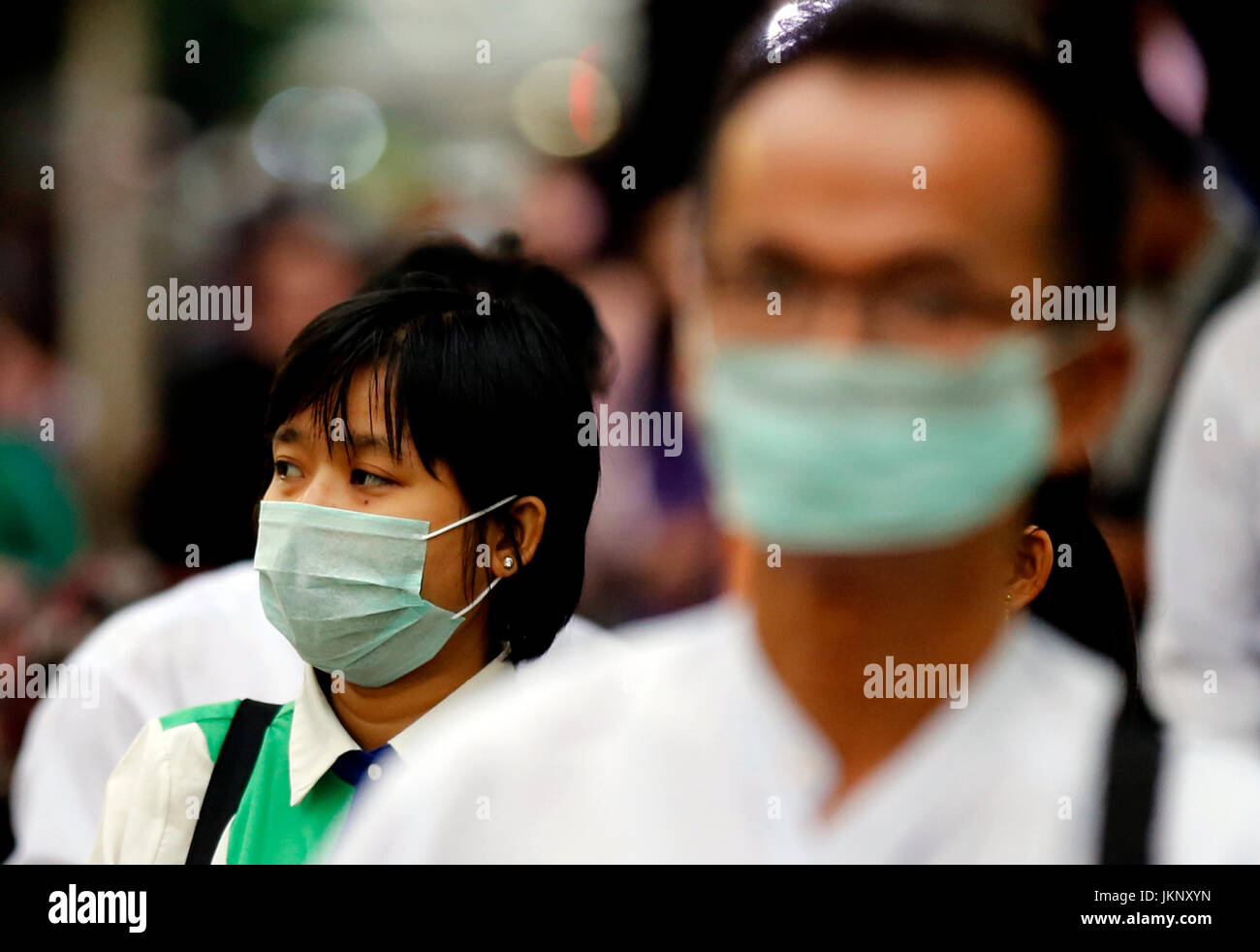 Yangon, Myanmar. 24. Juli 2017. Menschen tragende Masken warten auf Busse an einer Bushaltestelle in Yangon, Myanmar, 24. Juli 2017. Eine Person aus 13, infiziert mit saisonalen Grippe H1N1 2009 in Myanmar, ist nach einer Freigabe des Ministeriums für Gesundheit und Sport Montag gestorben. Bildnachweis: U Aung/Xinhua/Alamy Live-Nachrichten Stockfoto