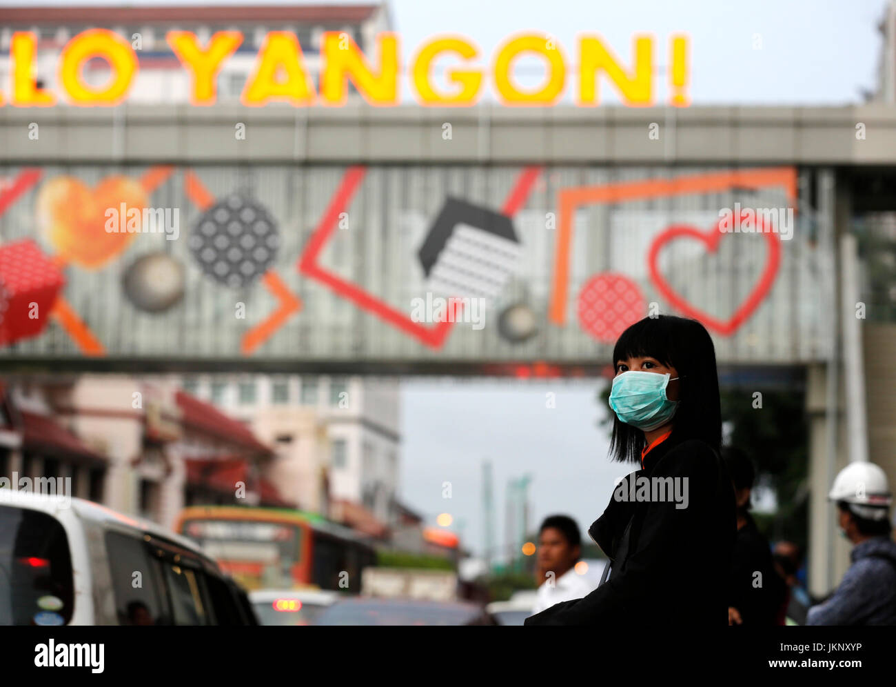 Yangon, Myanmar. 24. Juli 2017. Eine Mädchen trägt eine Maske wartet ein Bus an einer Bushaltestelle in Yangon, Myanmar, 24. Juli 2017. Eine Person aus 13, infiziert mit saisonalen Grippe H1N1 2009 in Myanmar, ist nach einer Freigabe des Ministeriums für Gesundheit und Sport Montag gestorben. Bildnachweis: U Aung/Xinhua/Alamy Live-Nachrichten Stockfoto