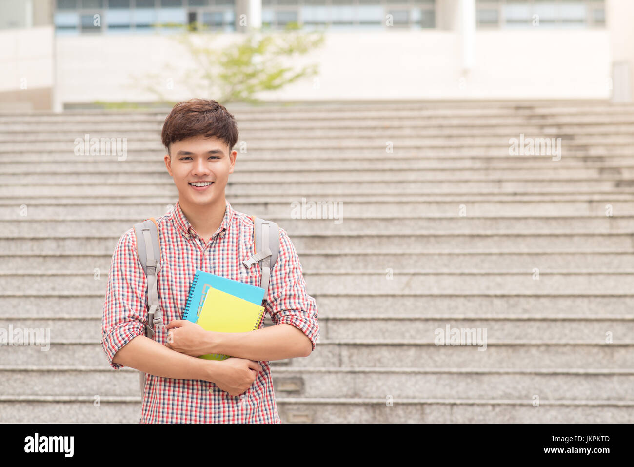 Asiatische Studentin mit seinen Büchern auf dem campus Stockfoto