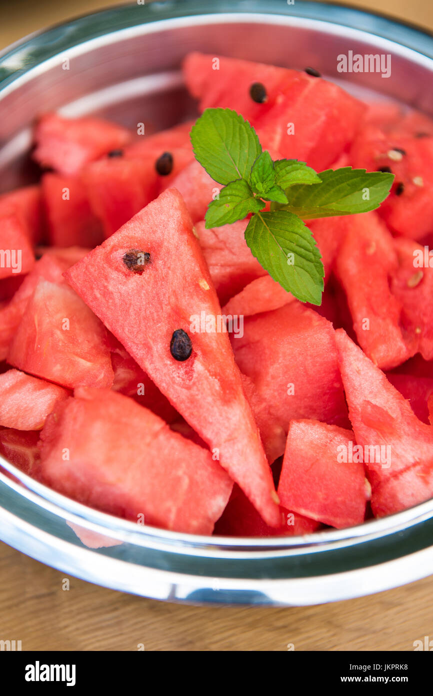 Süße rote Wassermelone Stücke in eine Schüssel geben, garniert mit frischer Minze Stockfoto