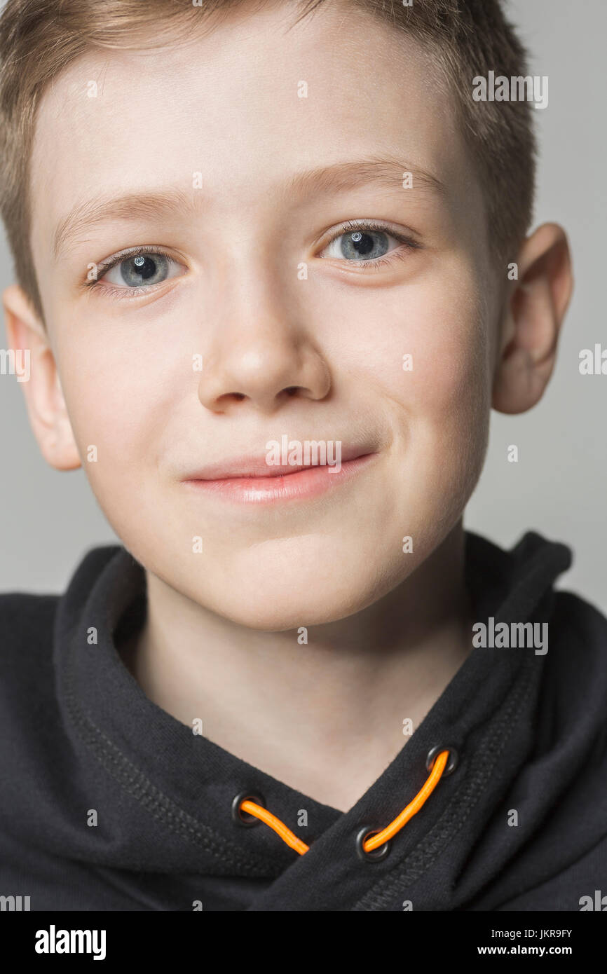 Porträt eines lächelnden jungen grauen Hintergrund Stockfoto
