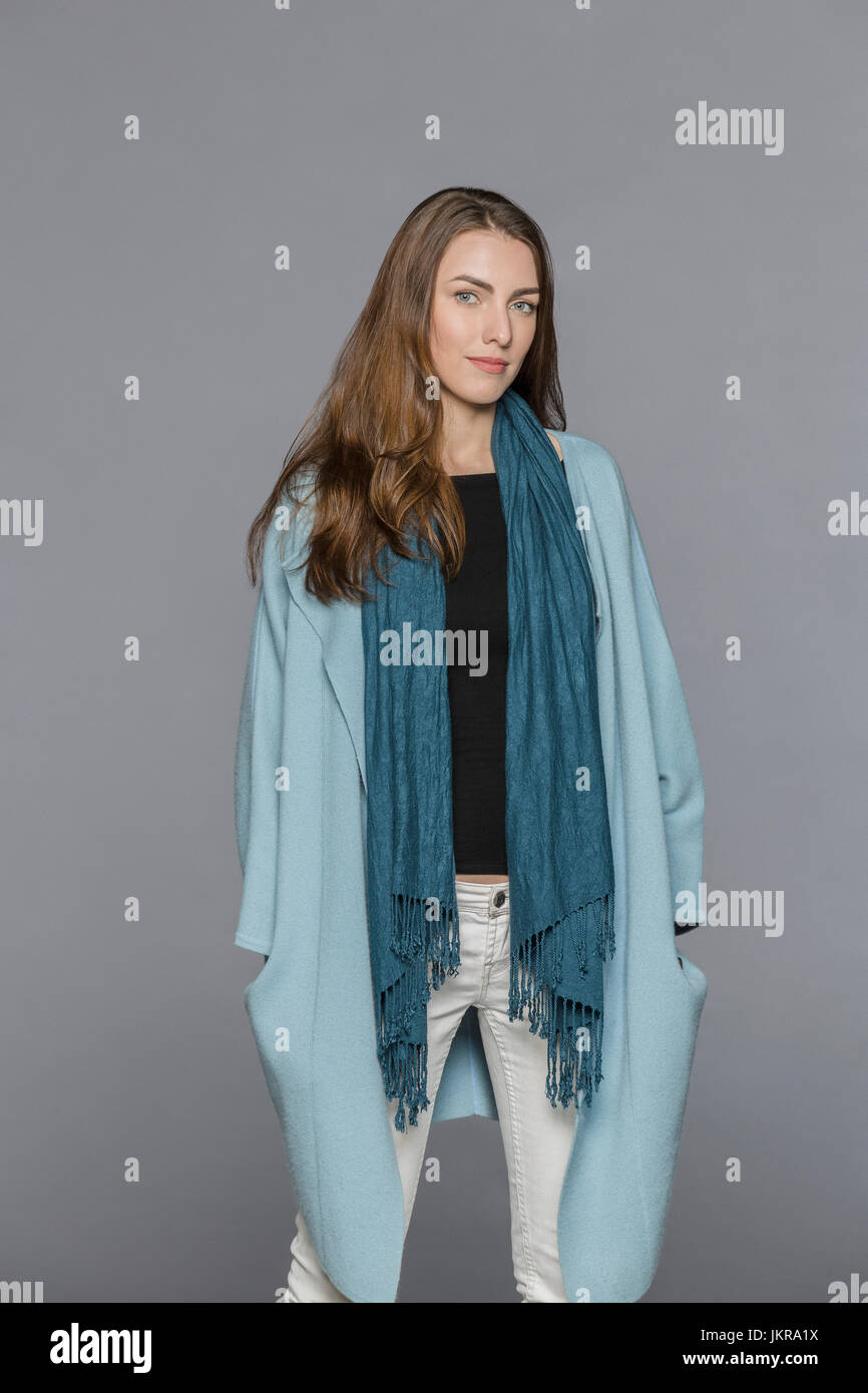 Porträt der schönen jungen Frau stand vor grauem Hintergrund Stockfoto