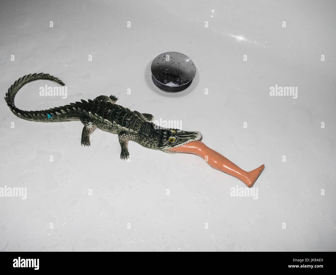 Erhöhte Ansicht Krokodil Spielzeug Essen Kunststoff Bein in weiße Wanne Stockfoto