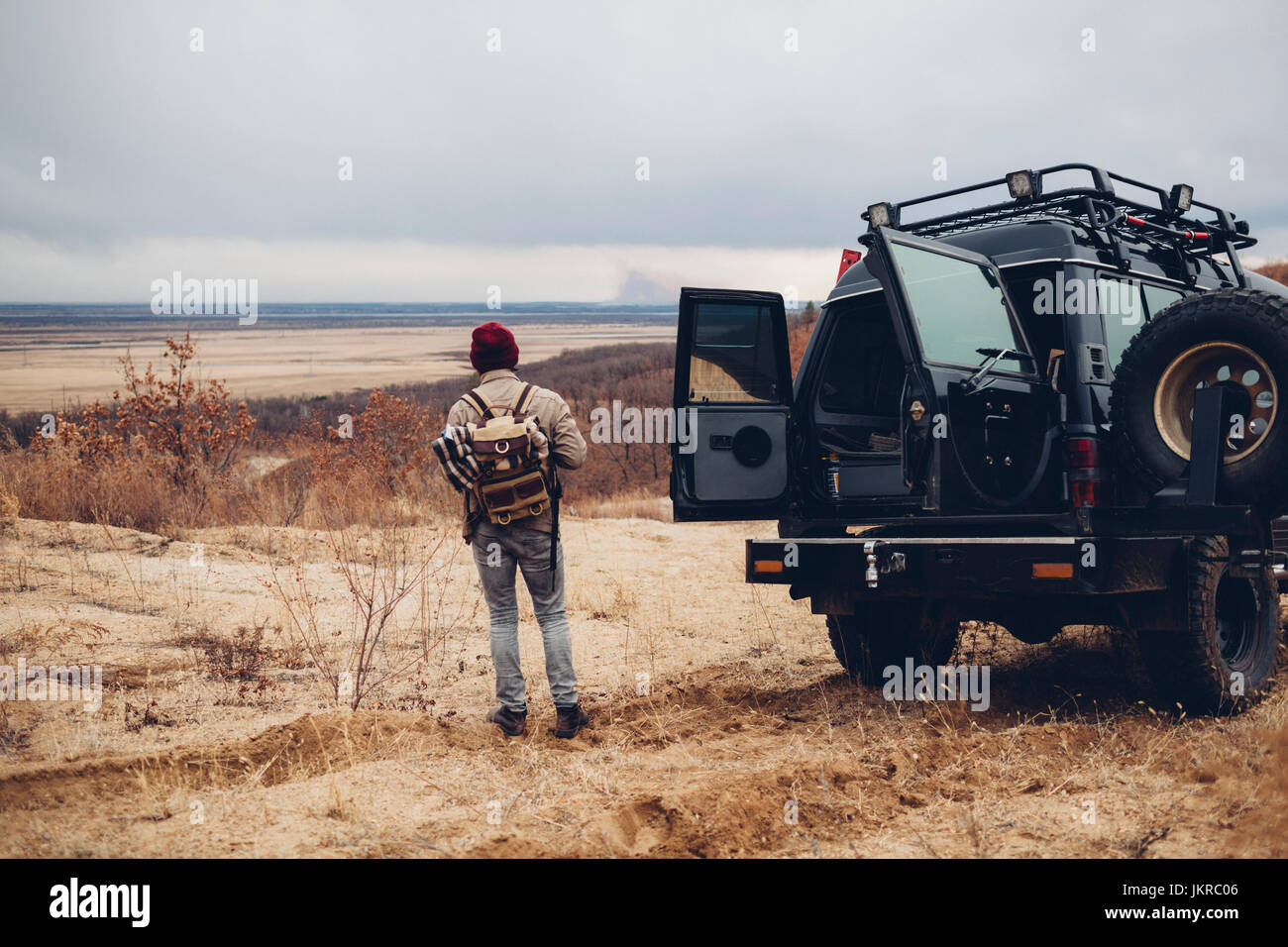 Rückansicht des Wanderer stehend durch Sport Utility Vehicle an Land gegen Himmel, Amur, Russland Stockfoto