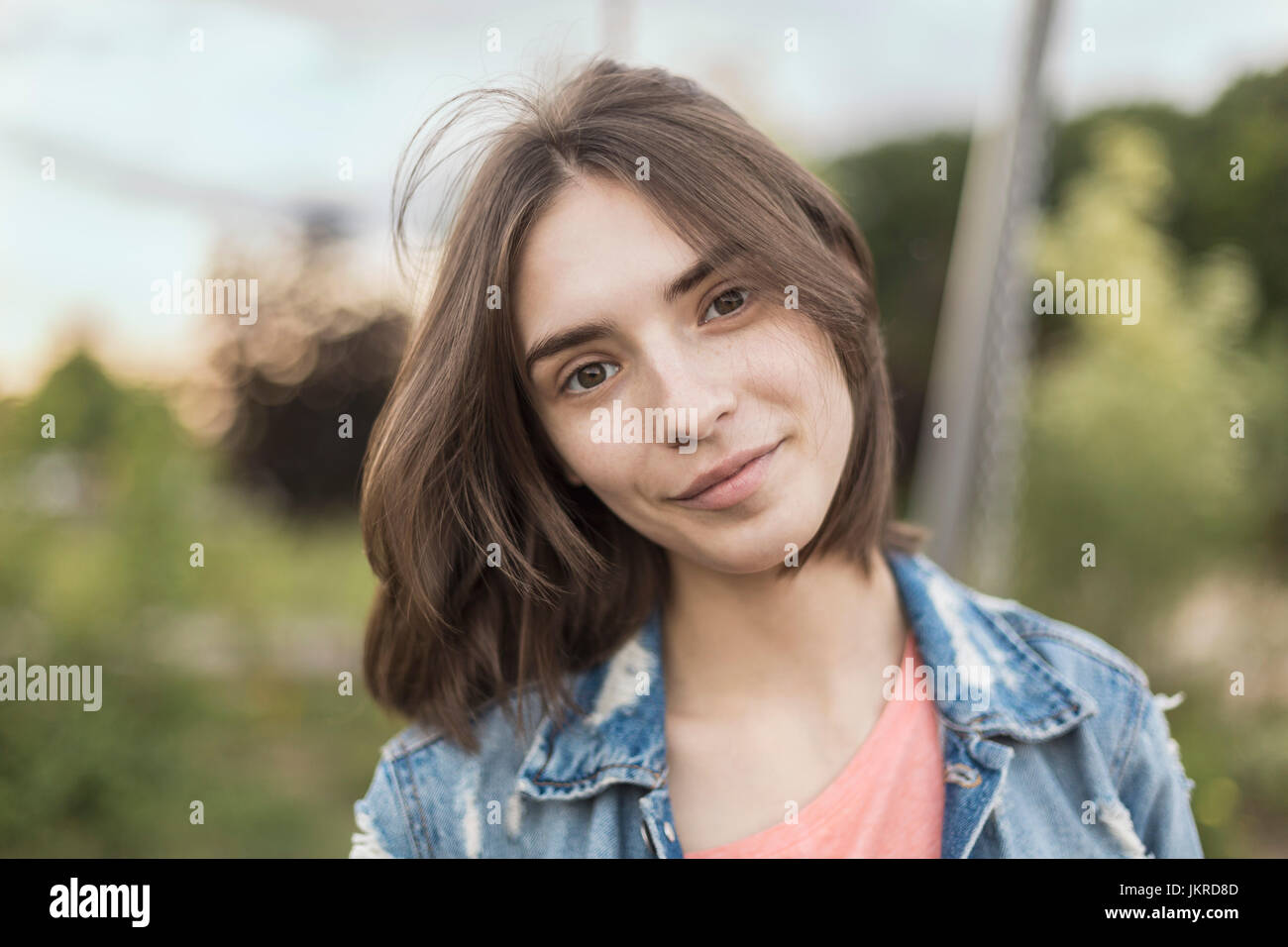 Porträt der lächelnde junge Frau mit Kopf gespannt im park Stockfoto
