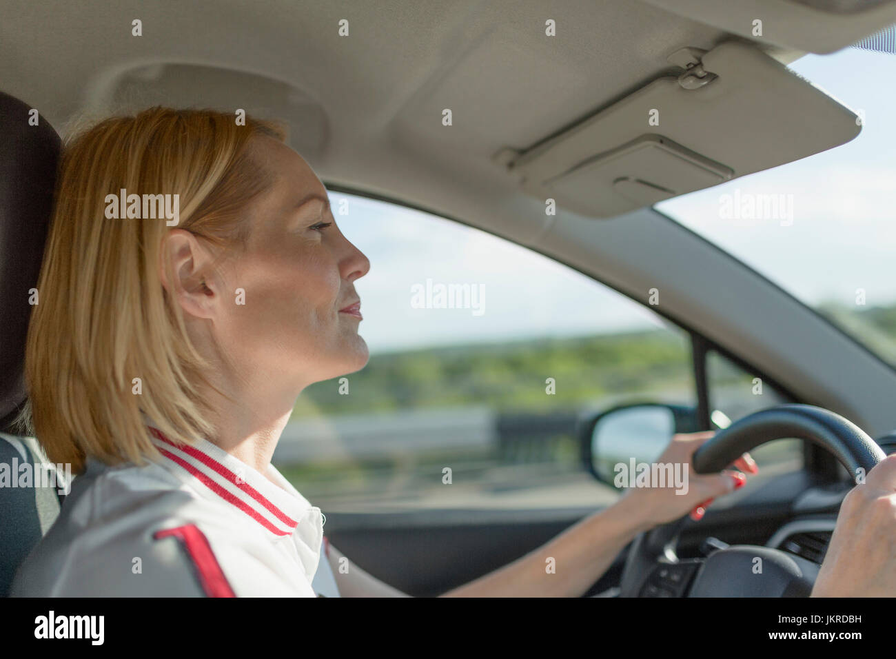 Seitenansicht des zuversichtlich Reife Frau Autofahren an sonnigen Tag Stockfoto