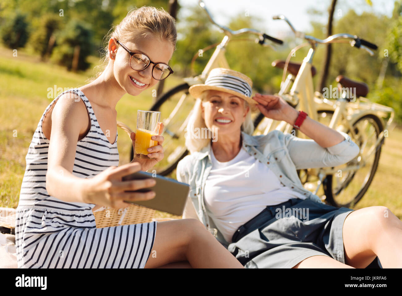 Positiven Großmutter und Teenager Mädchen genießen Picknick im grünen Stockfoto