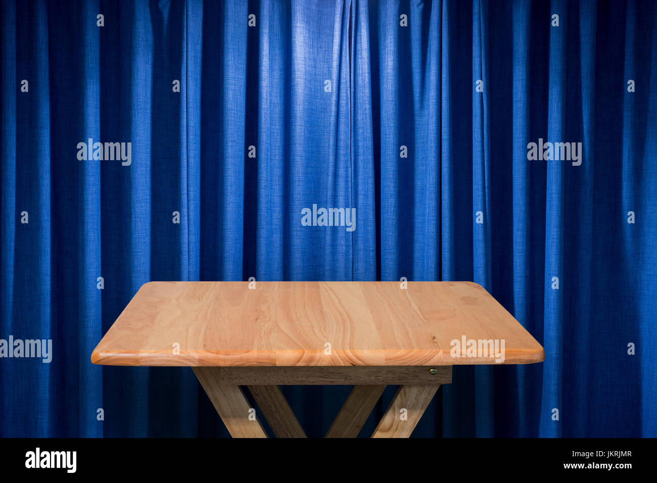 Holztisch mit blauen Vorhang Hintergrund Stockfoto