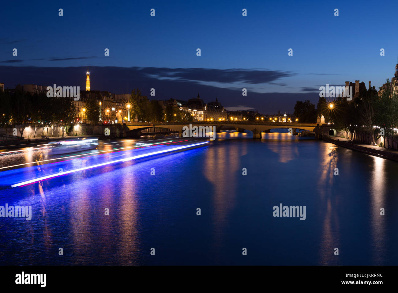 Paris bei Nacht, Skyline von Seineufer mit Boot Strahl von Licht und Blick auf Eiffelturm Stockfoto