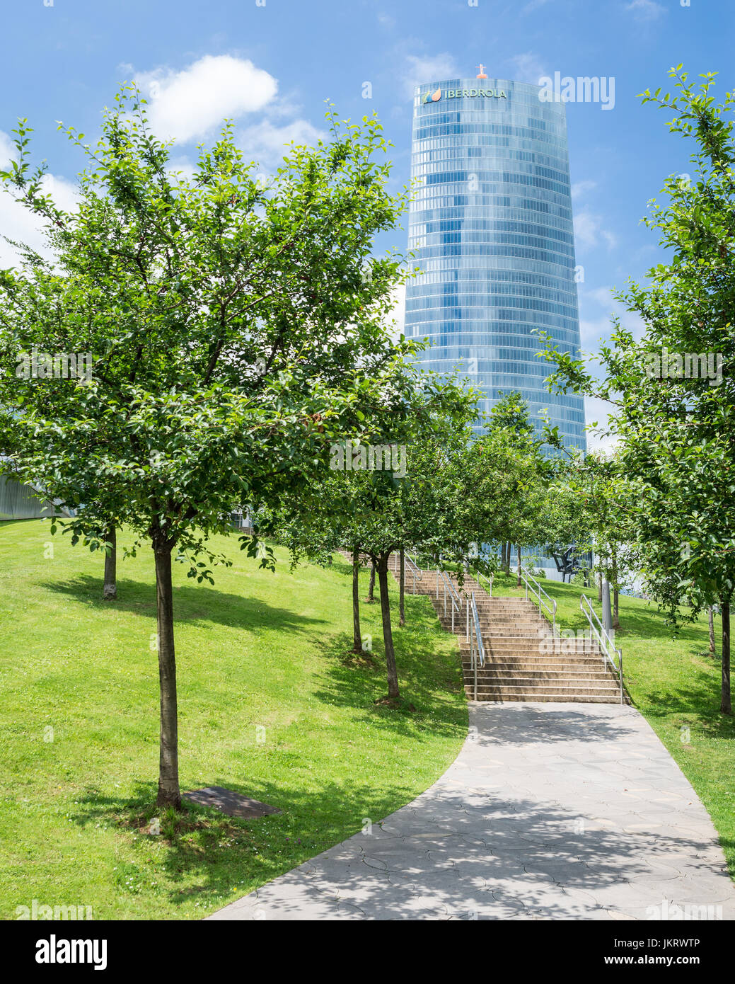 Ansicht von Iberdrola Tower mit grünen Bäumen und blauer Himmel Stockfoto