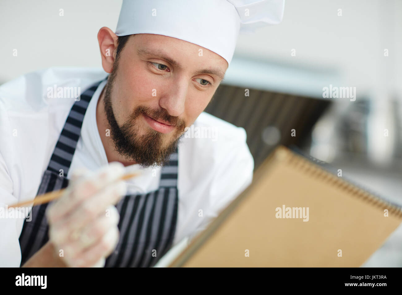 Koch schreiben Rezept oder Menü des Tages Stockfoto