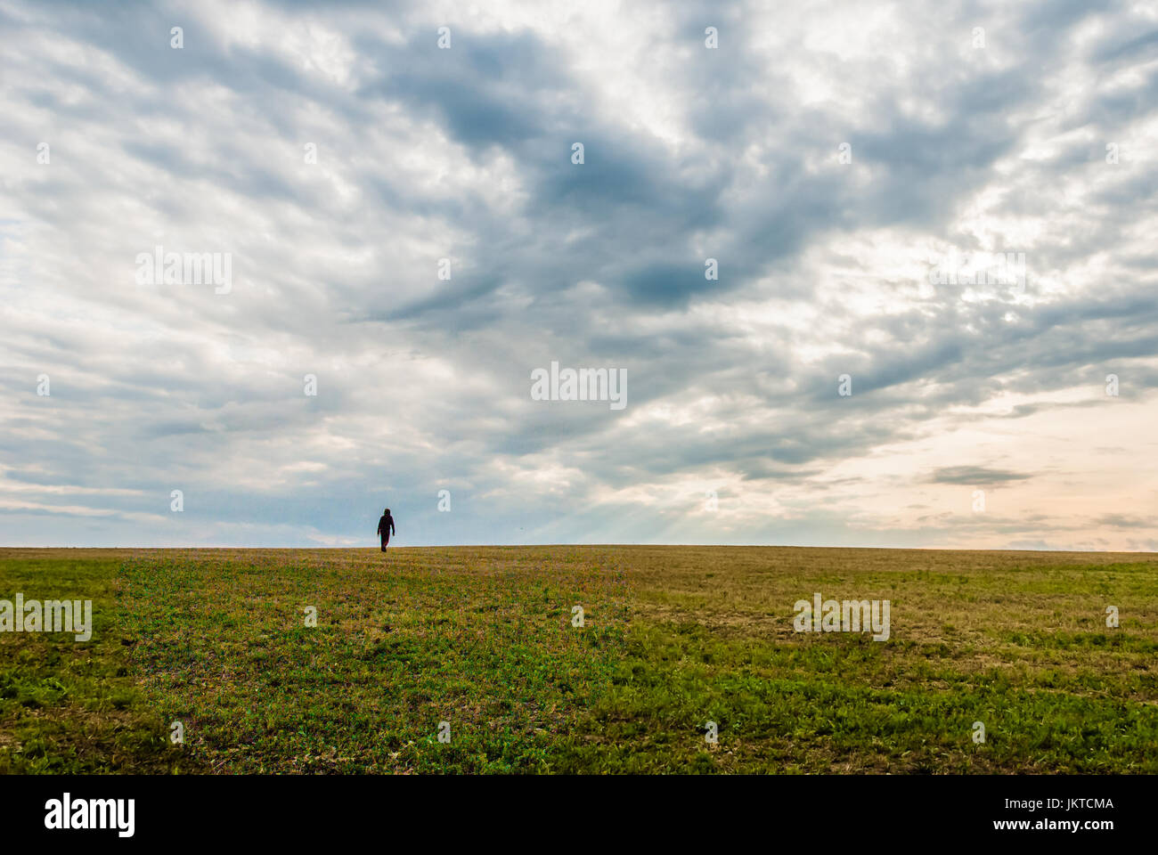 Ein einsamer Mann zu Fuß auf den Horizont der Landschaft unter einem dramatischen aussehenden Himmel. Gefühl von Einsamkeit und Angst. HDR, erschossen. Stockfoto