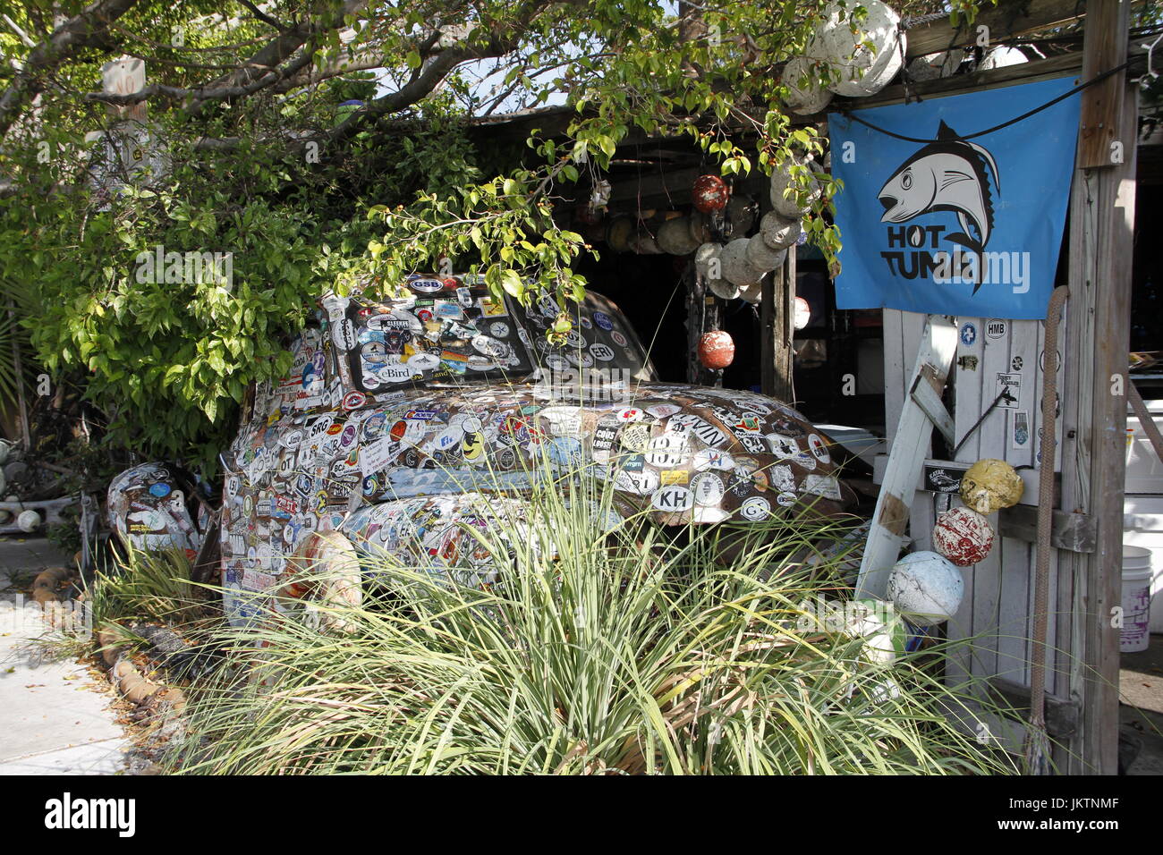 Eingerichtete alte Fahrzeug zwischen Bäumen mit Hot Tuna Flagge, Key West Florida ausgeblendet Stockfoto