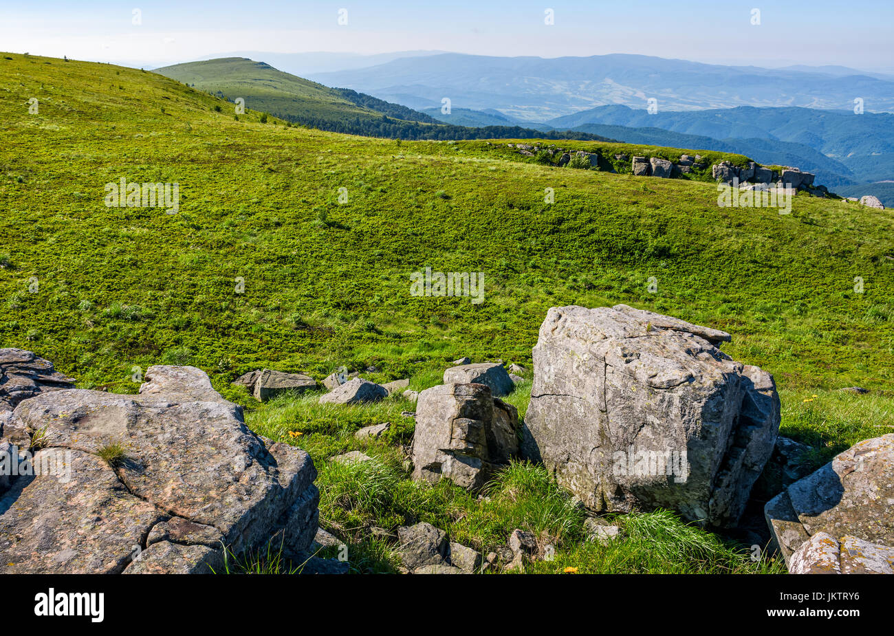 Berg-Sommer-Landschaft. Wiese mit riesigen Felsen unter dem Rasen oben auf dem Hügel in der Nähe der Spitze des Bergrückens Stockfoto