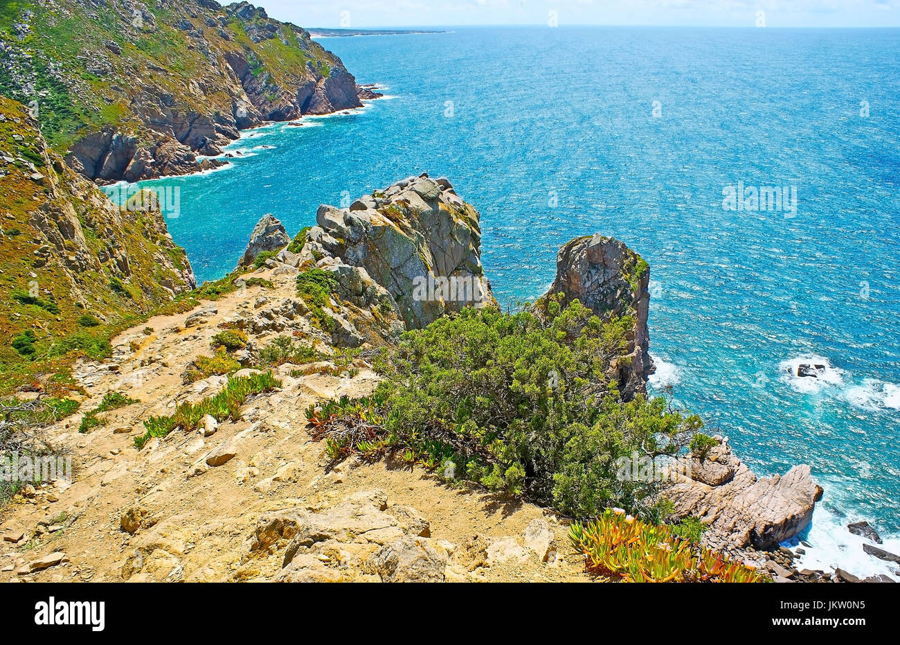 Die malerische Natur des Cape Roca mit Berglandschaft, zahlreiche Hottentotten-Fig Pflanzen, Felsen Deckung und leuchtend blauen Wasser des Atlantischen Ozeans, Stockfoto