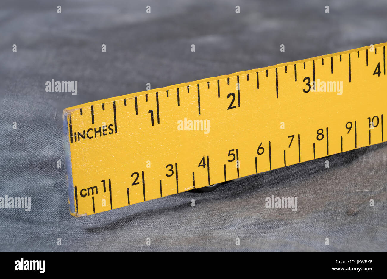 Gelbe Lineal mit Zoll und Zentimeter skaliert Stockfoto