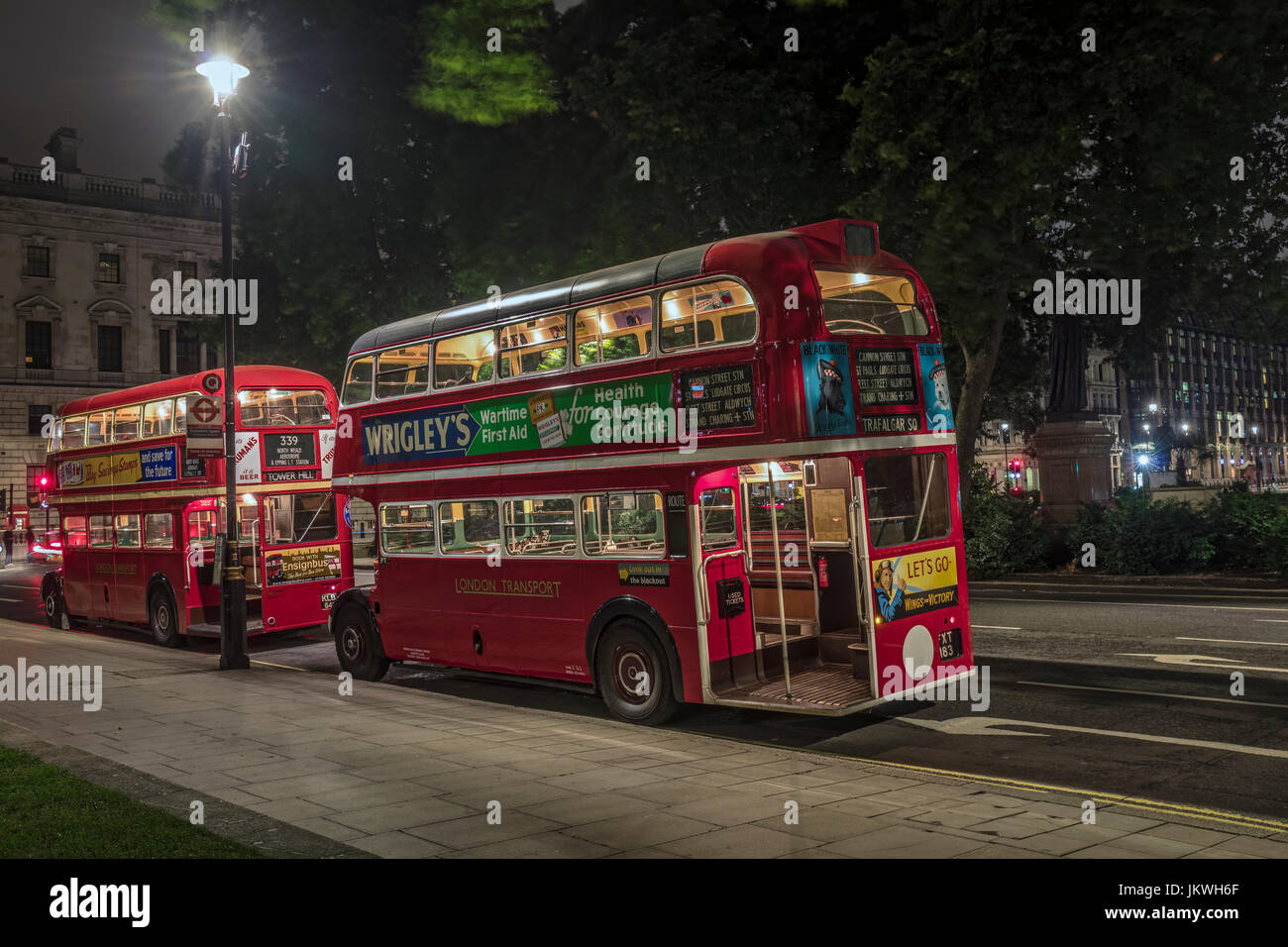 Zwei rote Oldtimer Busse in Parliament Square bei Nacht Stockfoto