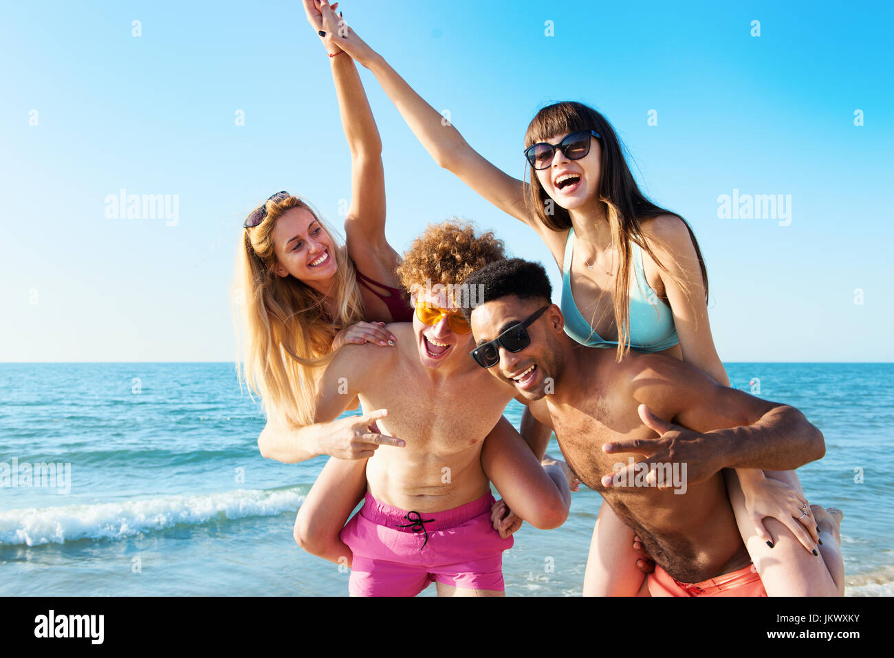 Fröhliche junge Freunde, genießen im Sommer am Strand Stockfoto