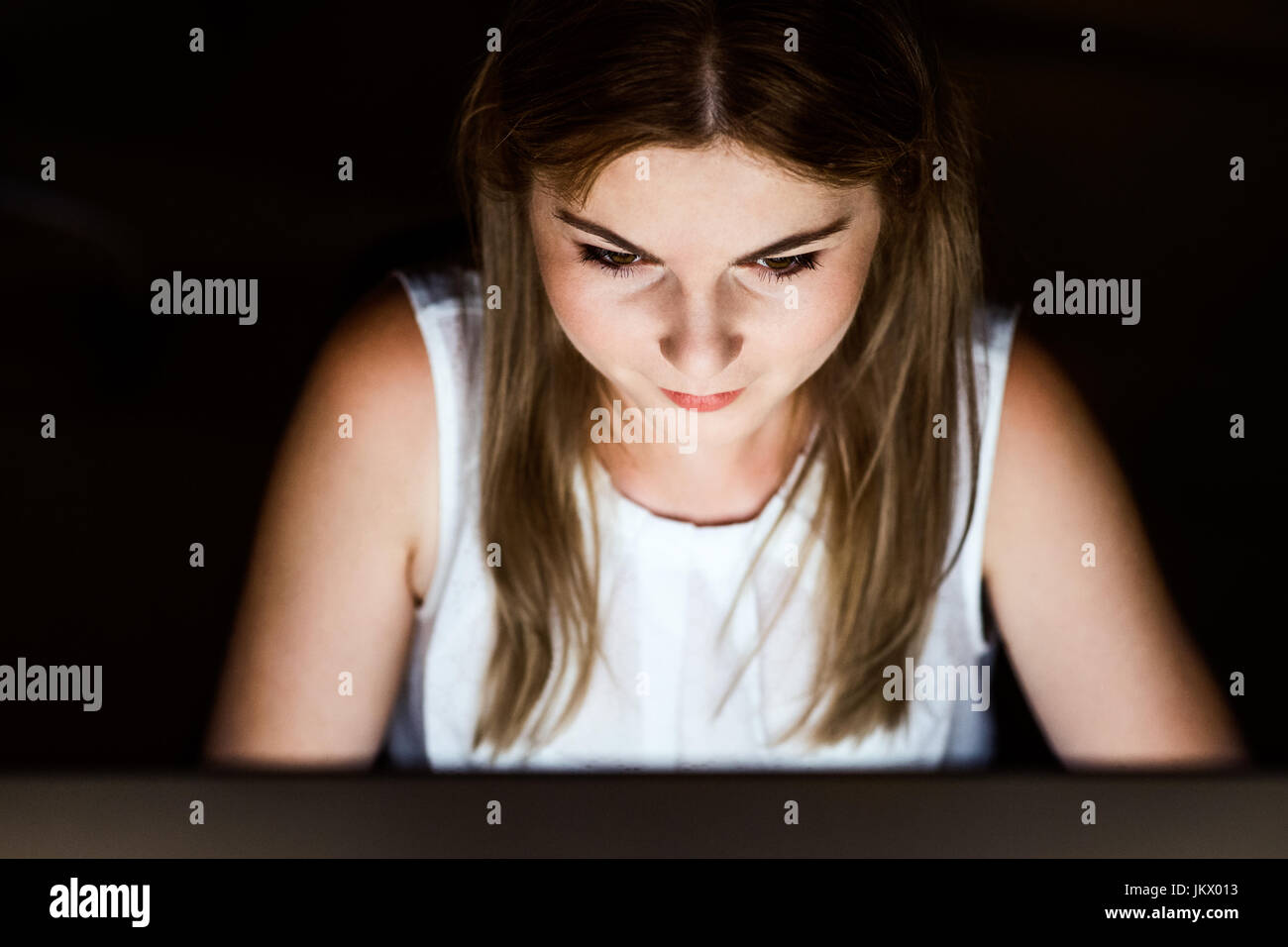 Geschäftsfrau vor Computer-Bildschirm im Büro in der Nacht. Stockfoto