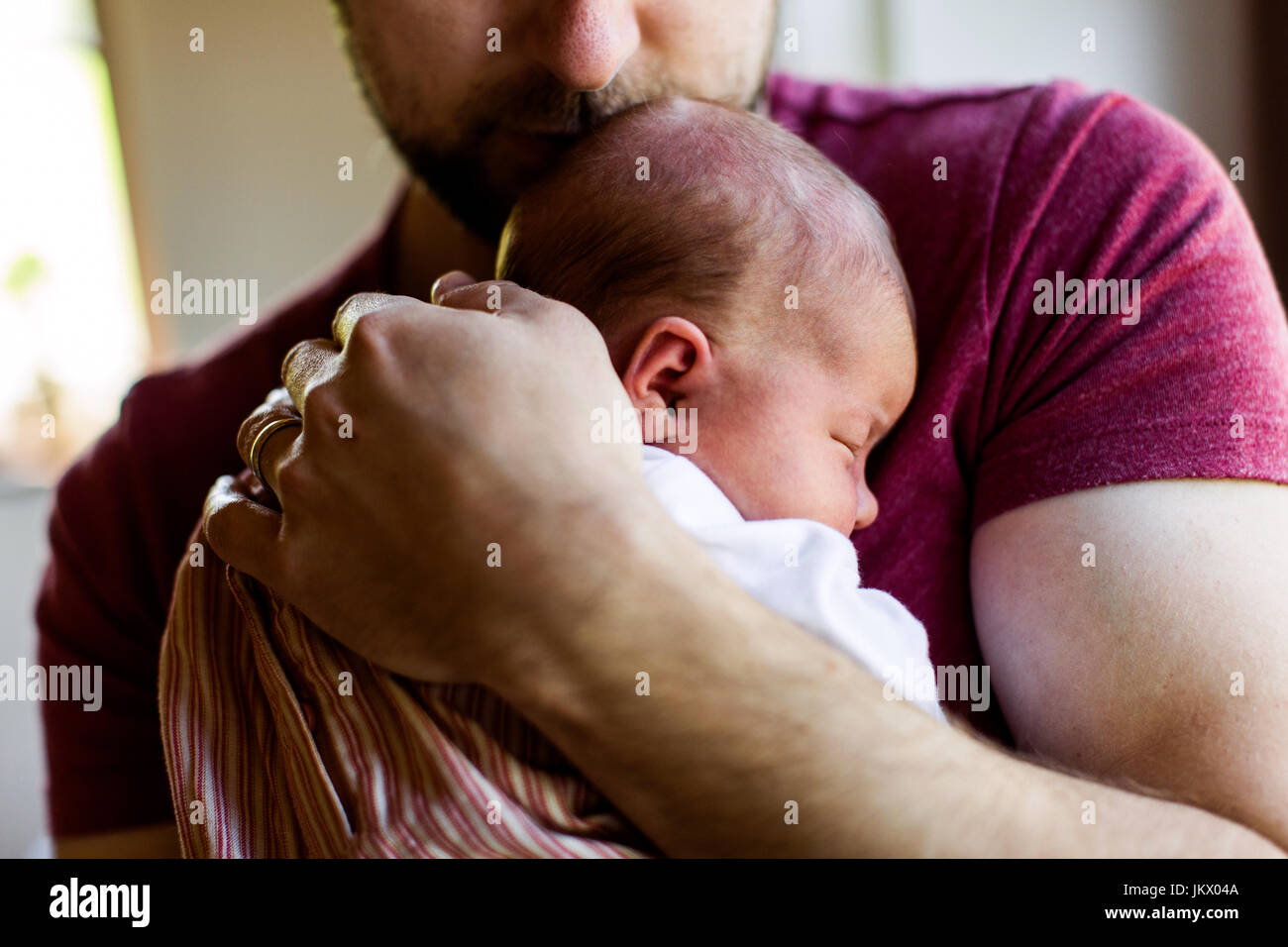 Nicht erkennbare junger Vater zu Hause hält sein neugeborenes gir Stockfoto