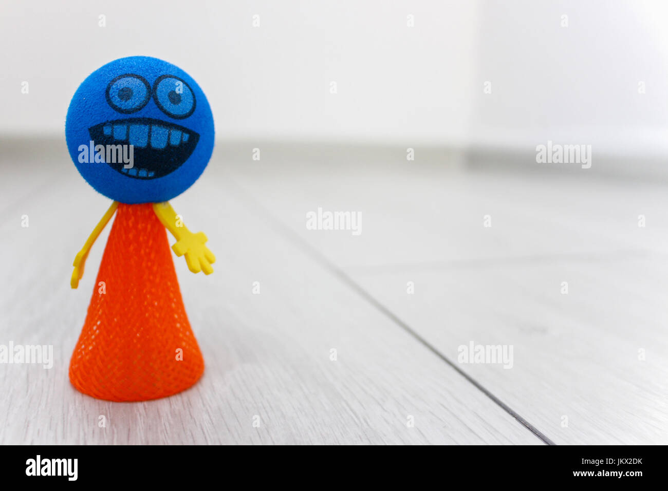 Blau und orange Spielzeug Smiley auf dem Boden Stockfoto
