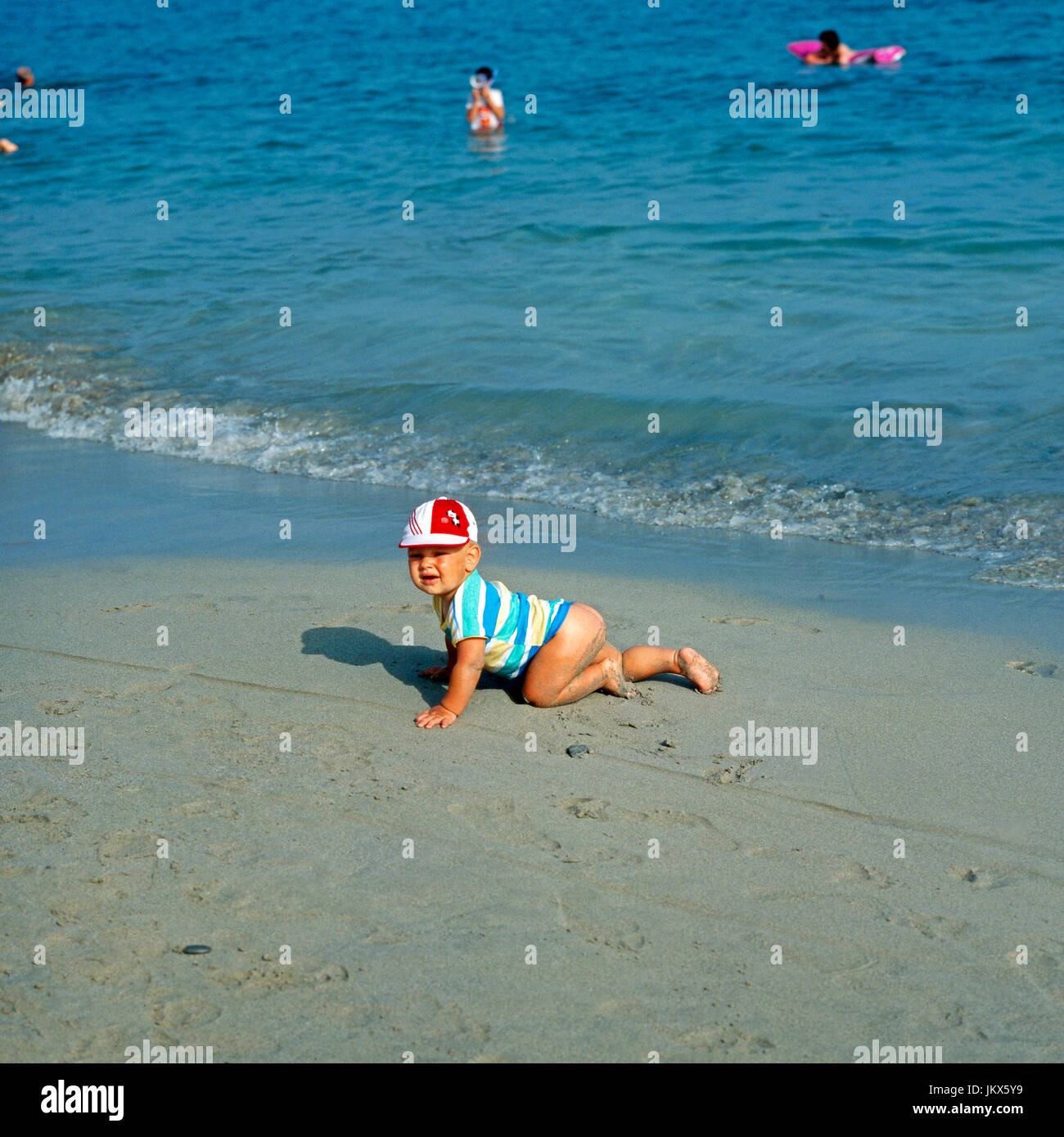 Ein Baby Krabbelt bin Strang. Ein Kleinkind krabbeln am Strand. Stockfoto
