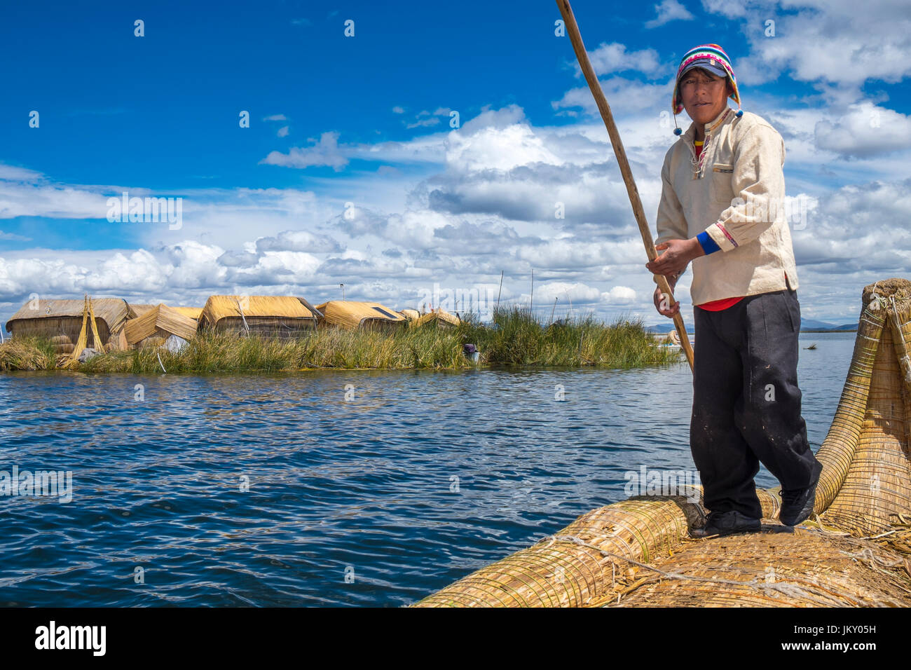 UROS-Inseln, PERU - ca. APRIL 2014: Mann von den Uros Inseln im Titicaca-See Rudern in typischen Kanu von Totora-Schilf gemacht. Stockfoto