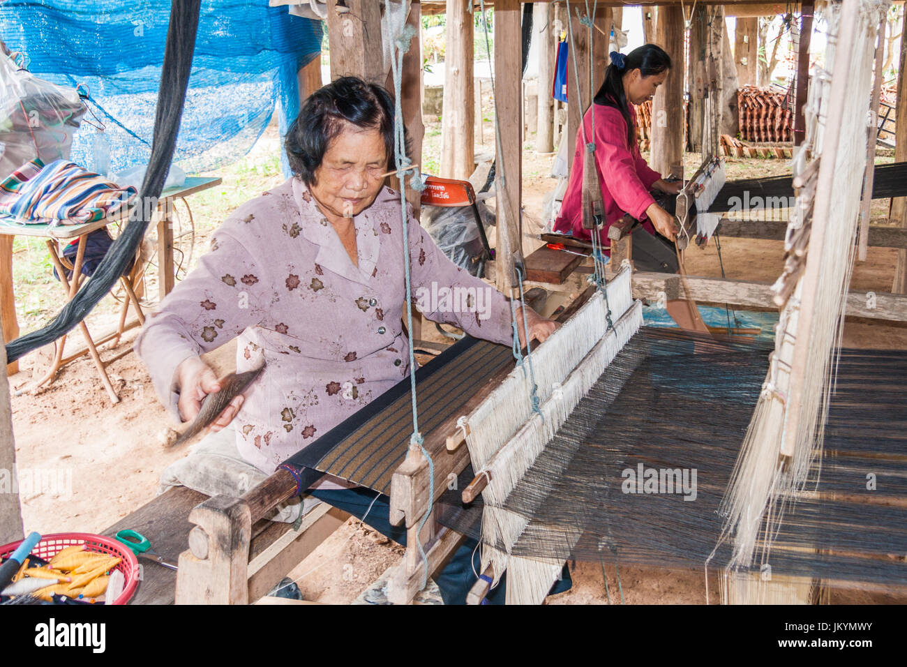 Thai Ladies Weberei Tuch unter einem Haus in Nan, Isaan, Nordthailand Stockfoto
