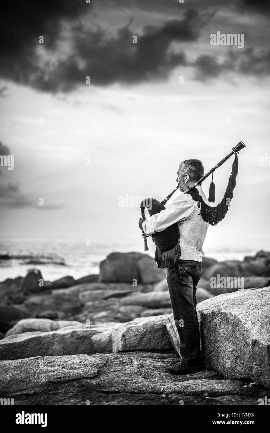 Mann spielt auf dem Dudelsack an der Küste des Ozeans inder Muxi, Spanien, Europa, Camino de Santiago. Stockfoto