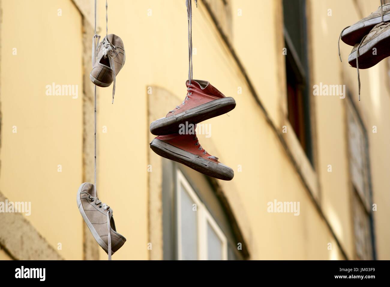 Alte Turnschuhe von einem Kabel hängen. Stockfoto