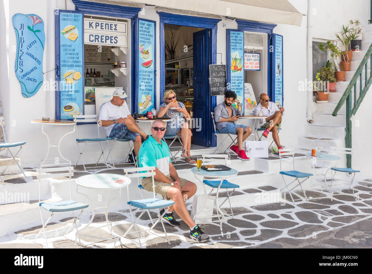 Menschen Essen und trinken vor einem Café in Mykonos, Griechenland Stockfoto
